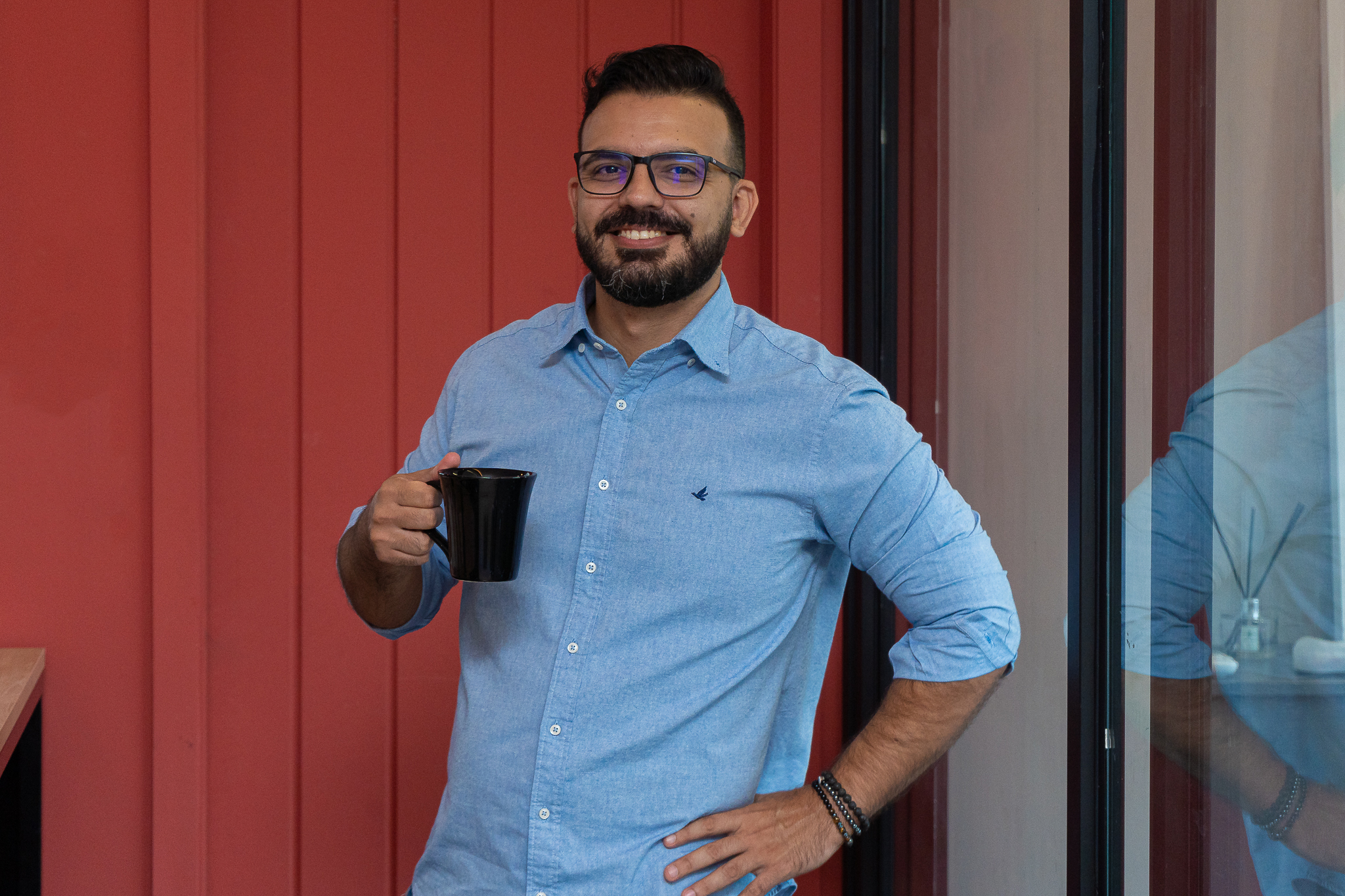 André segurando uma caneca de café